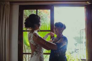 novia y su mamá ayudándola a poner el vestido